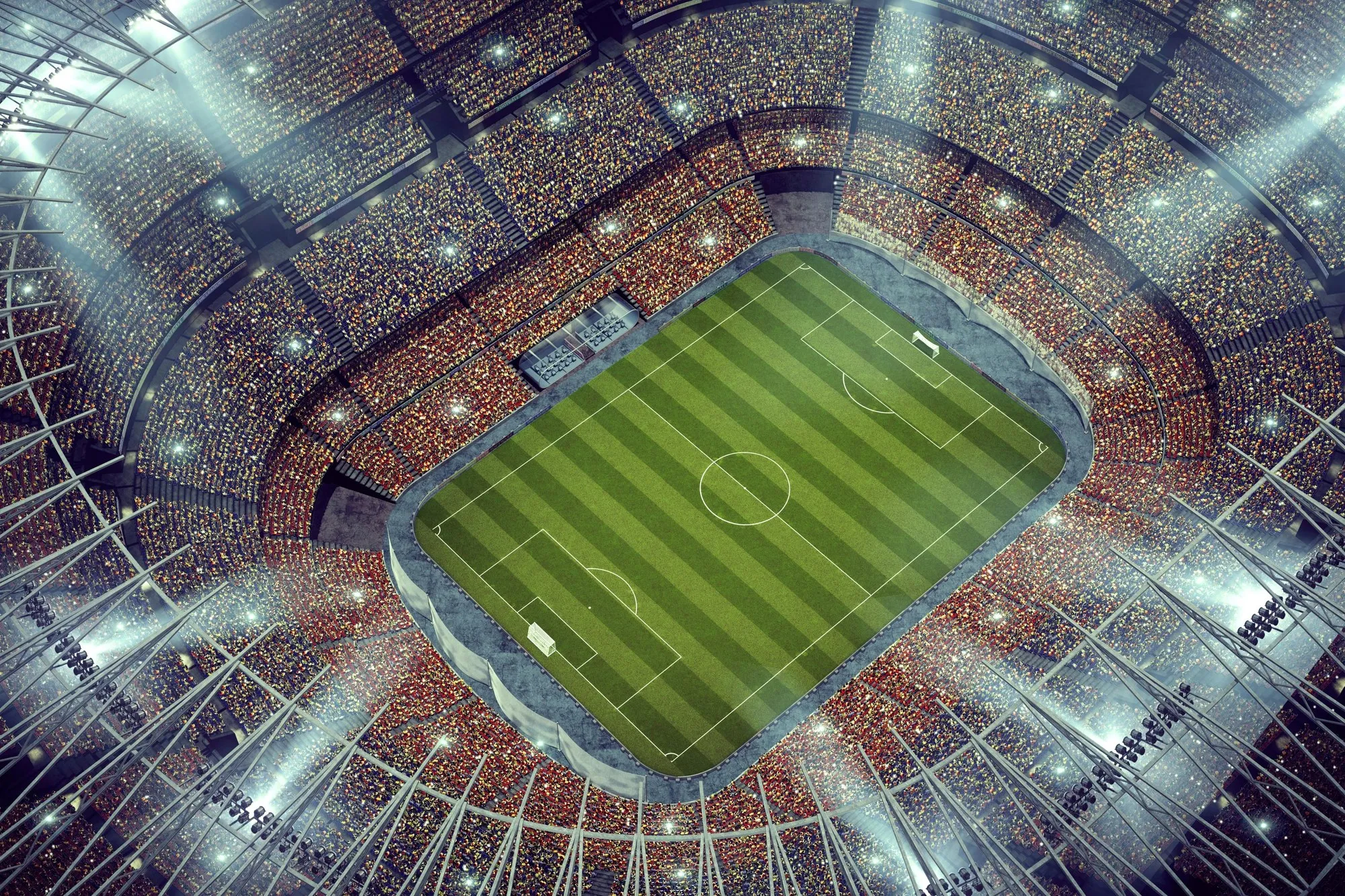 A football stadium under lights at night, seen from high in the stands